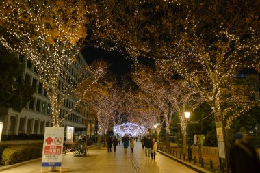 Osaka, Japonya - Aralık 2024: Osaka şehrinin canlı gece görüntüsü, Dotonbori veya Umeda gibi önemli bir bölge etrafında renkli aydınlatma ve neon ışıkları sergileniyor.
