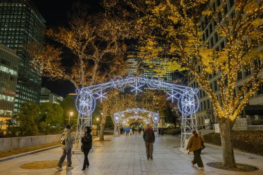 Osaka, Japonya - Aralık 2024: Osaka şehrinin canlı gece görüntüsü, Dotonbori veya Umeda gibi önemli bir bölge etrafında renkli aydınlatma ve neon ışıkları sergileniyor.