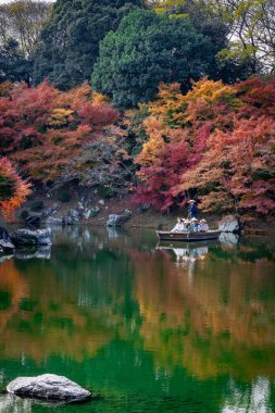 Takamatsu 'daki Ritsurin Parkı' nın sonbahar sezonunda nefes kesici manzarası. Kırmızı ve turuncu renkli akçaağaç ağaçlarıyla geleneksel Japon bahçesi, sakin yansıtıcı havuzlar.