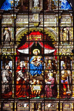 Gent, Belçika - 10 Temmuz 2010: Saint Nicholas Kilisesi 'nin içinde lekeli cam pencere. Meryem ve bebek İsa 'nın diğer kutsal insanlarla çevrili görüntüsü..