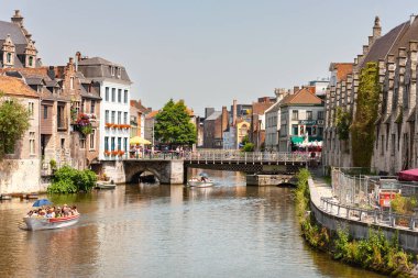 Gent, Belçika - 10 Temmuz 2010: Gent Nehri ve köprüleri, güneşli bir günde Vleeshuisbrug 'un (köprü) altından geçen küçük motorlu botlar.
