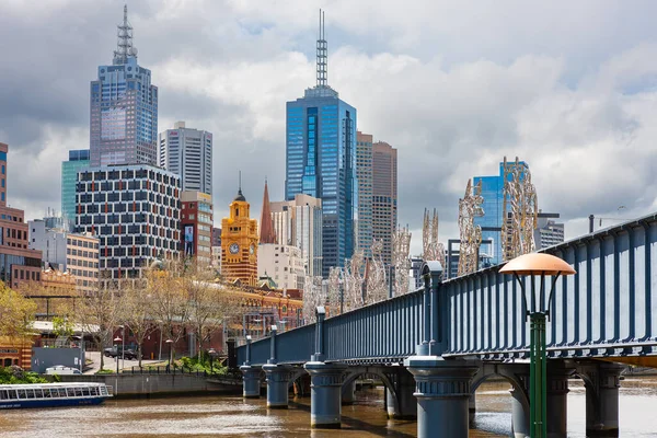 Melbourne, Avustralya - 28 Eylül 2010: Yarra River ve Melbourne kuzey bankası. Flinders Caddesi tren istasyonuna doğru giden yayalar için Sandridge Köprüsü.