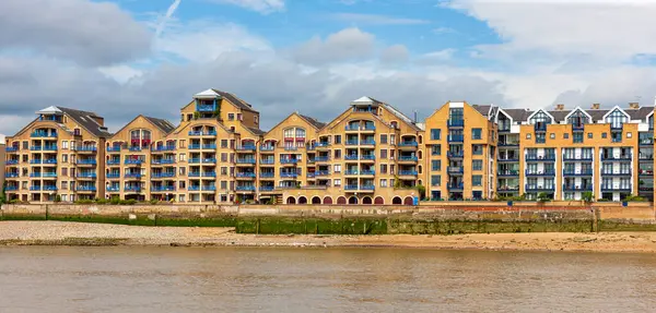 Thames nehrine bakan bir apartman. Wapping High Caddesi, Wapping, Londra, İngiltere 'de kahverengi ve mavi evler serisi.