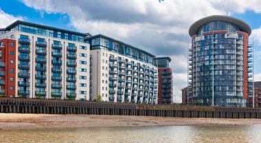 Newton Place ve Orion Point 'teki apartmanlar, Londra, İngiltere. Kuzey kıyısında Thames Nehri üzerinde mavi balkonlu birimler, Köpekler Adası..