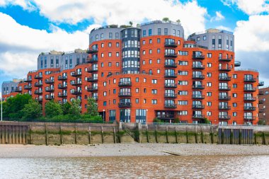 Kuzey kıyısı Thames Nehri, Londra, İngiltere 'deki kırmızı tuğlalı apartman kompleksi. 