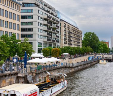 Berlin, Almanya - 18 Temmuz 2010: Berlin 'de River Spree' nin kuzey seti. Doğu Berlin 'e gidecek yolcuları almak için tur gemileri hazır..