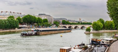 Paris, Fransa - 21 Temmuz 2010: Seine Nehri 'ndeki gemiler. Büyük bir mavna doğuya, Pont Neuf Köprüsü 'nün kuzeyine doğru yelken açarken küçük tekneler güney tarafında demirledi.). 