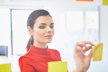 Ofiste yapışkan notlarla çalışan güzel bir iş kadını.