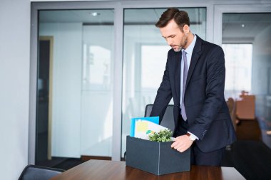 Kovulduktan sonra eşyalarını toplayan üzgün adam işini yapıyor.