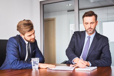 İş görüşmesi konsepti. Aday bilgilerini kontrol eden iki üye.