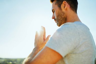Güneşli bir günde açık havada dua eden bir adamın portresi
