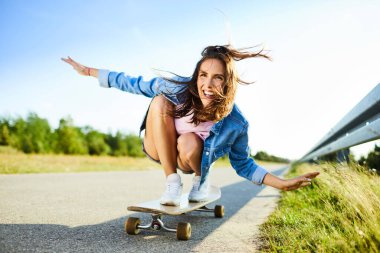 Kırsal alanda uzun sörf yapan neşeli genç bir kadın.