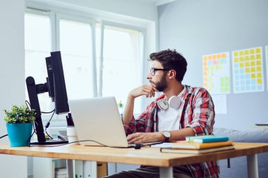 Ekrana bakan ve iş projesini düşünen genç web geliştiricisinin yan görünümü