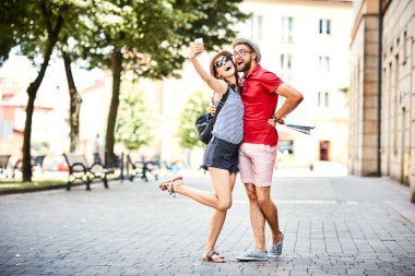 Genç bir çift şehirde tatildeyken selfie çekiyor.
