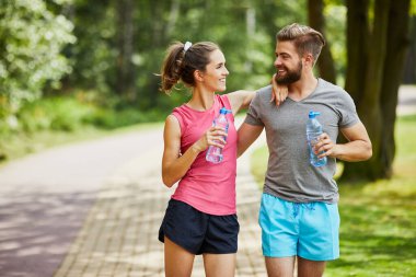 Genç çift parkta birleşip kucaklaşırken ara veriyor.