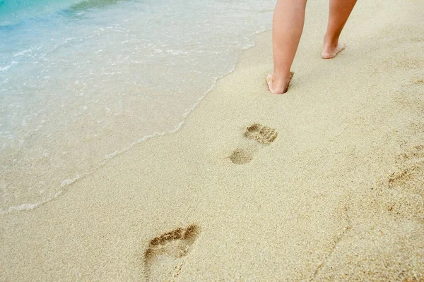 海滩旅行妇女在沙滩上悠闲自在地走着 在沙滩上留下了脚印 希腊海滩上一只金黄色沙滩上的雌性脚的特写 — 图库照片