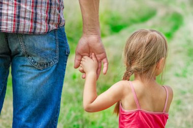 Park aile kavramında mutlu çocuk ve ebeveynin elleri
