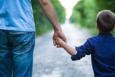  Bir çocuğun elleri ve bir ebeveynin yol yolculuğunun arka planında