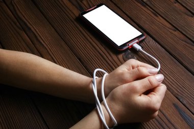 Telefon ahşap bir arka planda el bağımlılığı