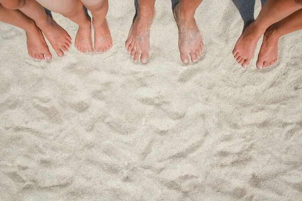 Feet on the sand of happy people by the sea on nature travel