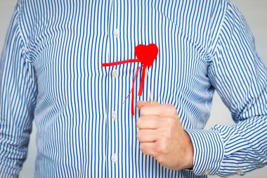 Heart in human hands on white brick background