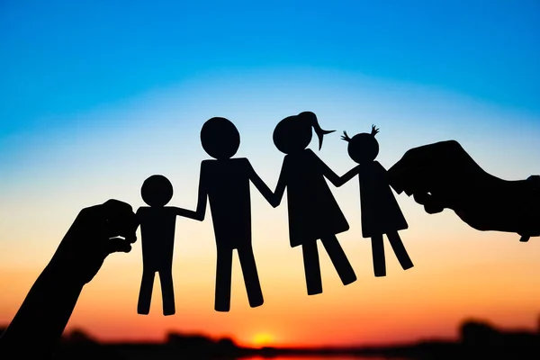 silhouette family, including his father, mother and two children in the hands of