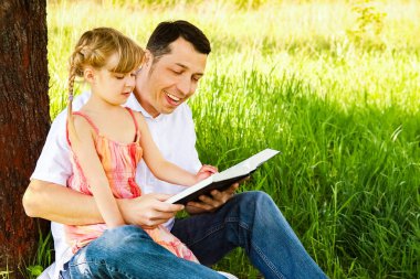 İncil okuyan küçük bir kızı olan genç bir baba.