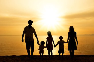 Doğada mutlu bir aile deniz kenarında bir siluette