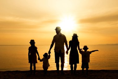 Doğada mutlu bir aile deniz kenarında bir siluette