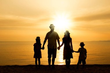 Doğada mutlu bir aile deniz kenarında bir siluette