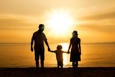 Doğada mutlu bir aile deniz kenarında bir siluette