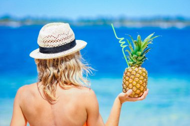 Doğada deniz kenarında bir adamın elinde ananas bir yolculukta