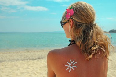 Denizde mutlu bir kız Sırtında güneşin bir resmiyle