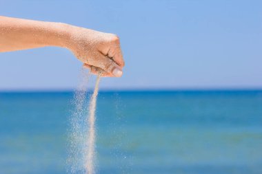 Eller doğaya yolculukta denizden kum döker. Deniz kumlarında tatiller geçer..