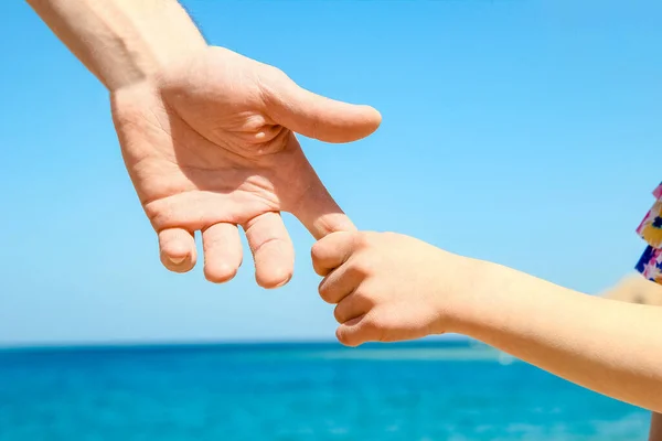 海岸の背景に親子のスタイリッシュな手 — ストック写真