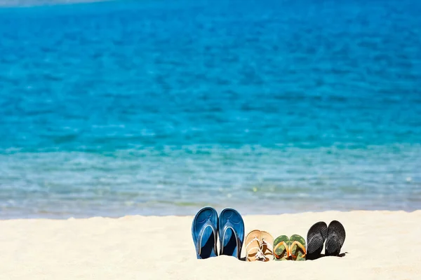 全家的拖鞋在海边的沙滩上 在大自然的指引下旅行 穿鞋度假在水边休息 — 图库照片
