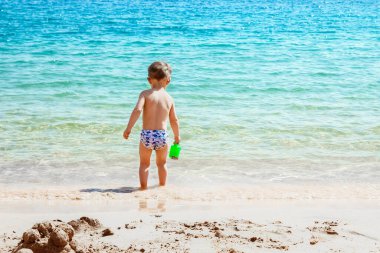 Mutlu çocuk deniz arka plan üzerinde oynarken