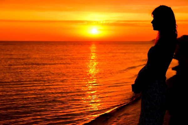 一个快乐的孕妇在夏天的海面上关于大自然的轮廓 — 图库照片