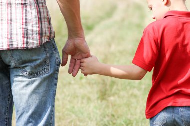 Park aile kavramında mutlu çocuk ve ebeveynin elleri