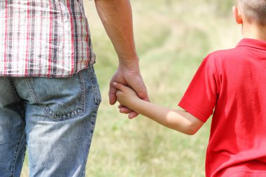 Park aile kavramında mutlu çocuk ve ebeveynin elleri