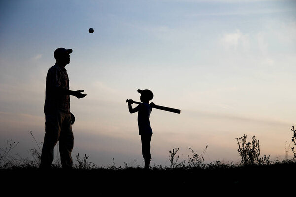 Силуэт ребенка с родителями играть бейсбол концепции семьи счастливы в парке на природе