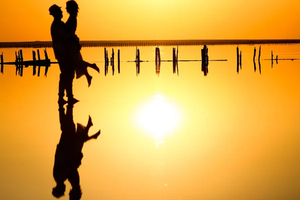 一对快乐的情侣在海上与水反射轮廓背景 — 图库照片