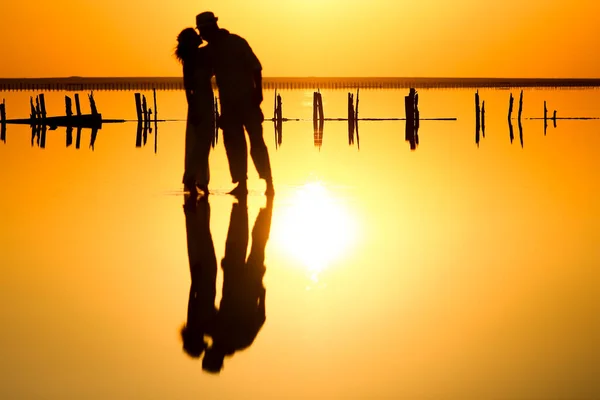 stock image happy couple at sea with water reflection silhouette background