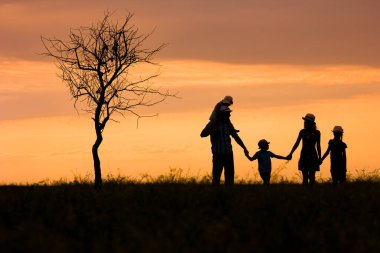 Park arka planındaki mutlu aile silueti