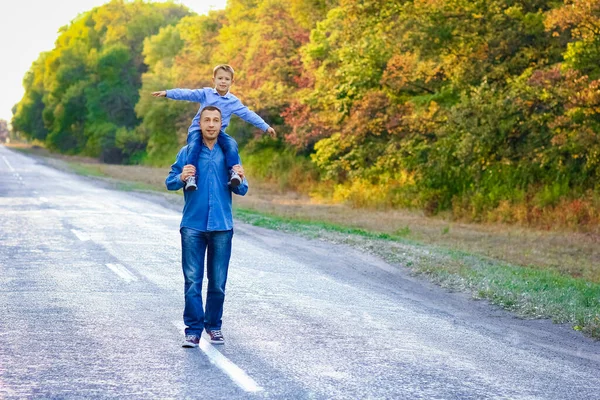自然旅行で公園の手に子供と幸せな親は道に沿って行きます — ストック写真