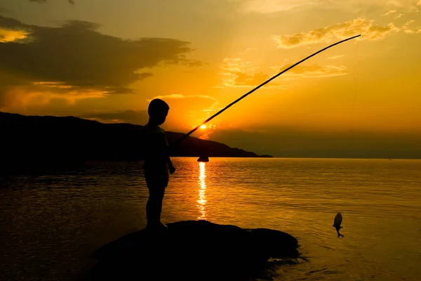 海のシルエットによる幸せな子供釣り — ストック写真