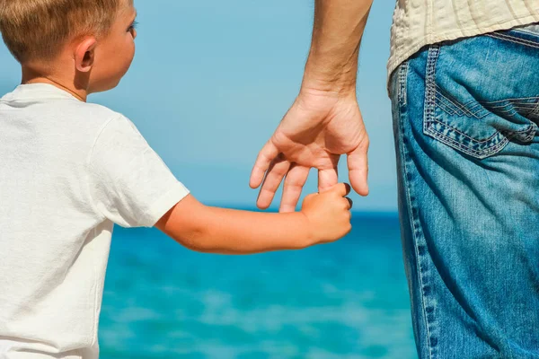 幸せなお父さんはギリシャの海のそばで子供の手を握ってる — ストック写真