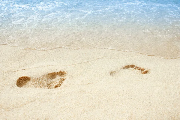 ビーチ旅行 砂の中に足跡を残して砂浜を歩くリラックスした女性 ギリシャのビーチで黄金の砂の上の女性の足の詳細を閉じます — ストック写真
