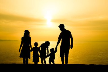 Doğada mutlu bir aile deniz kenarında bir siluette