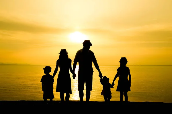 旅のシルエットで海に囲まれた幸せな家族 — ストック写真